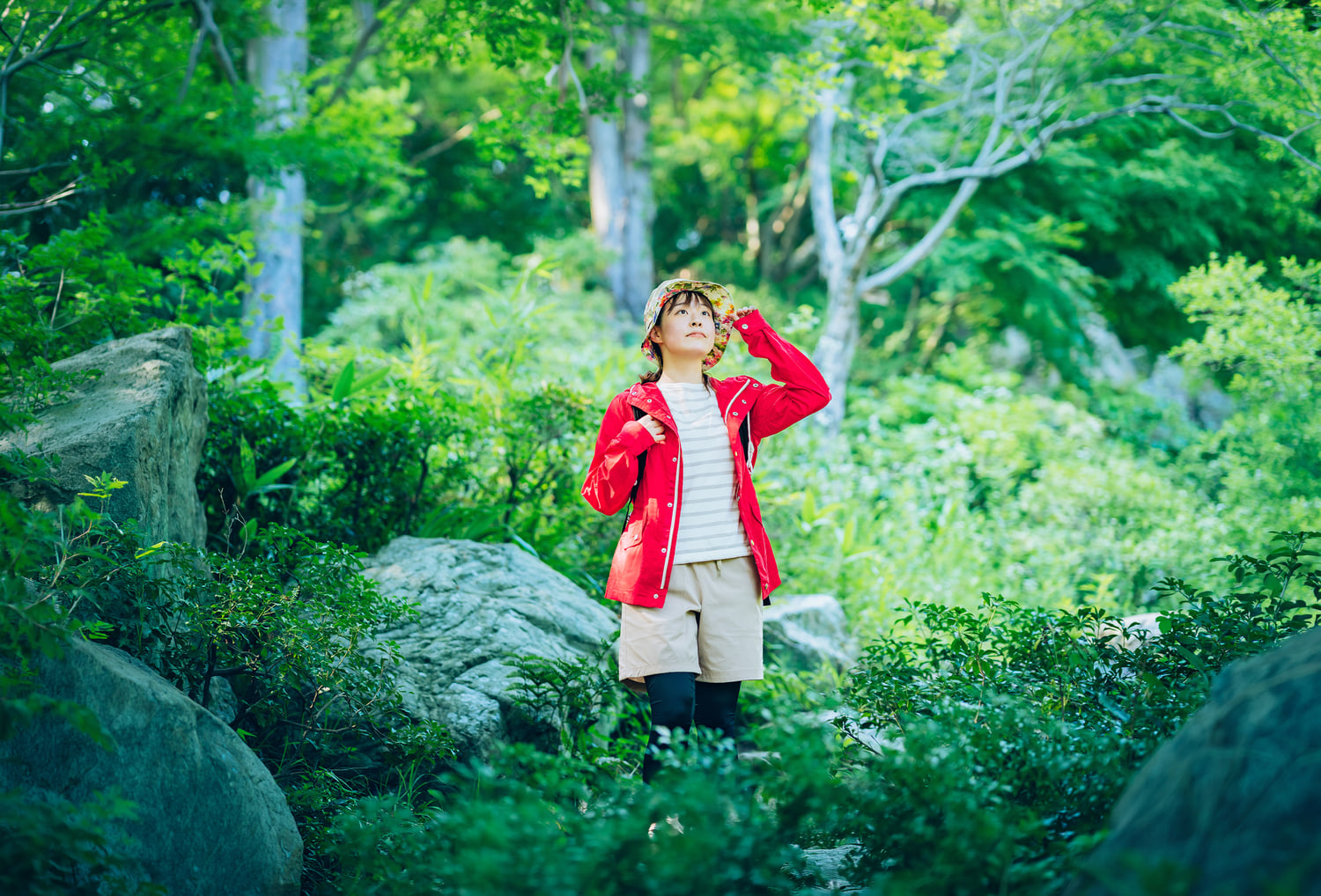 生成拡張で森の背景を広げた赤い服の人物写真