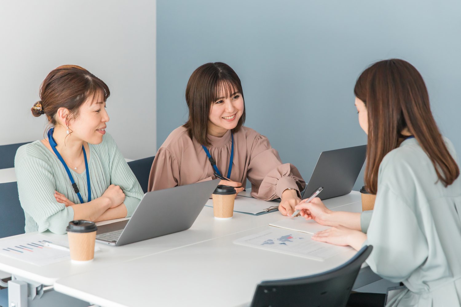 机上の資料を見ながら制作内容を相談する担当者たち