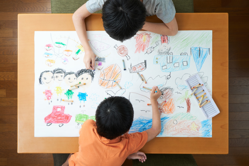 リビングで絵を描く小学生