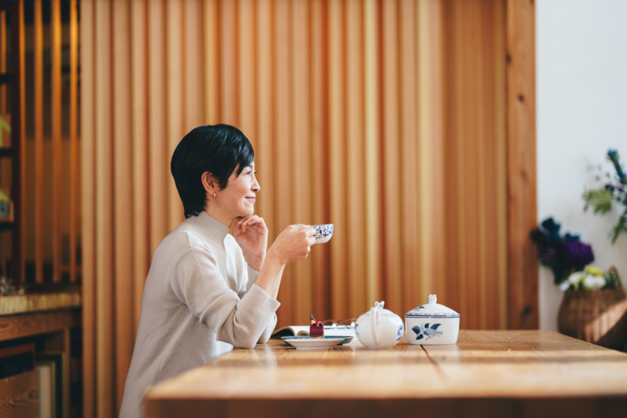 ティータイムに読書を楽しむ50代女性