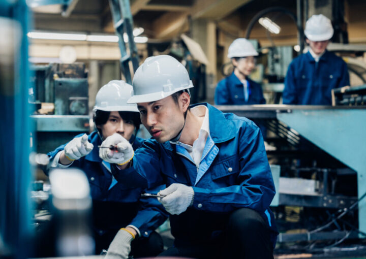工場で機械の整備をする労働者