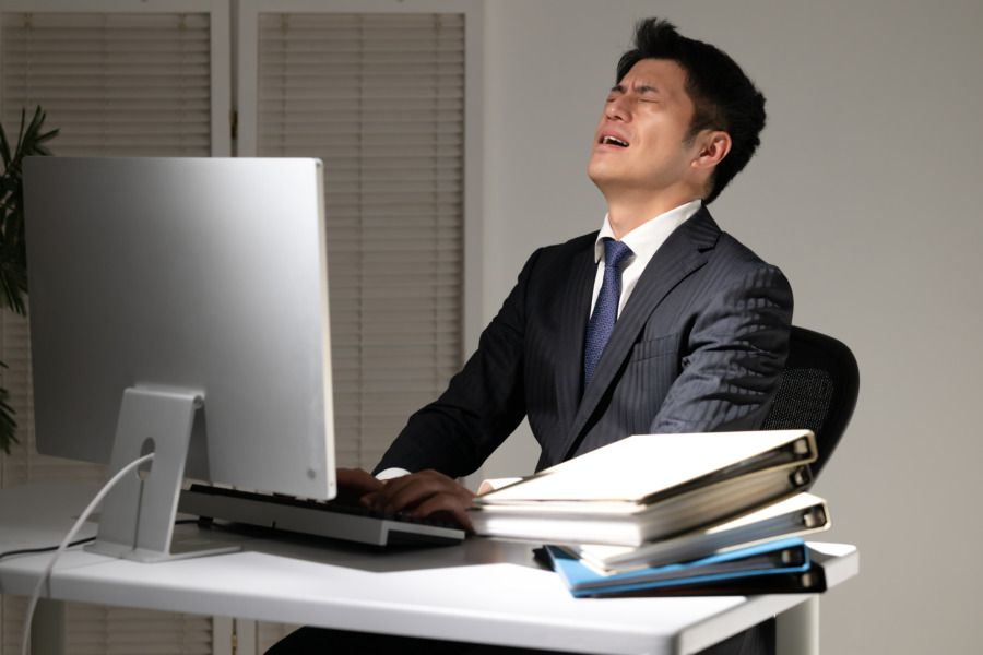 デスクワークに疲れる男性