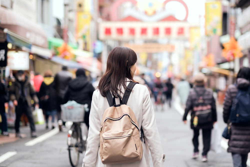 ショッピングストリートを歩く女性と歩行者たち