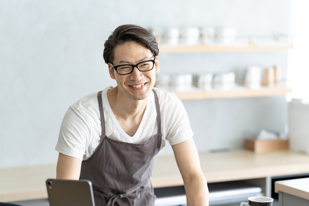 笑顔で接客するカフェ店員男性