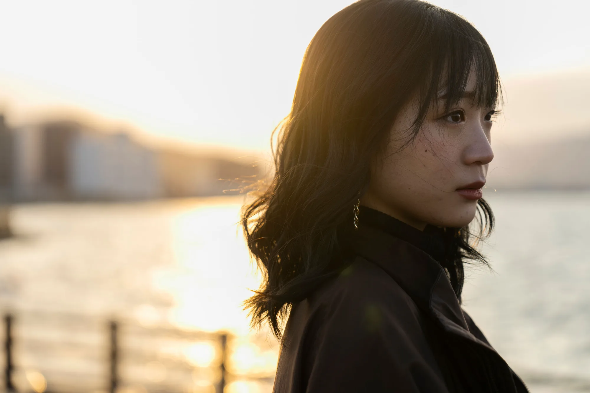 元写真：海辺で後ろを振り返る女性